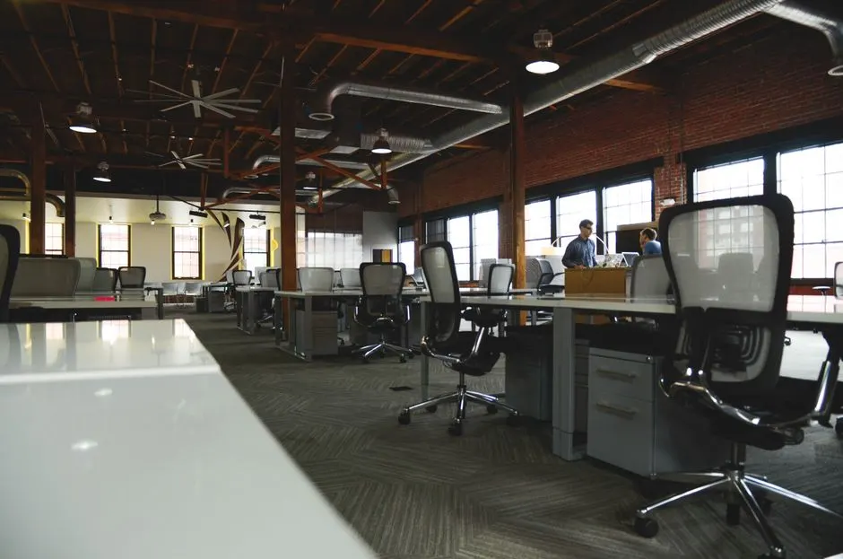 Open-plan industrial coworking space with modern design and natural lighting.
